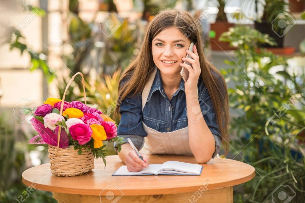 Esta imagen tiene el atributo alt vacío; su nombre de archivo es 38832811-retrato-de-floristeria-mujer-joven-hablando-por-telefono-y-haciendo-notas-en-la-tienda-de-flores--1024x683.jpg
