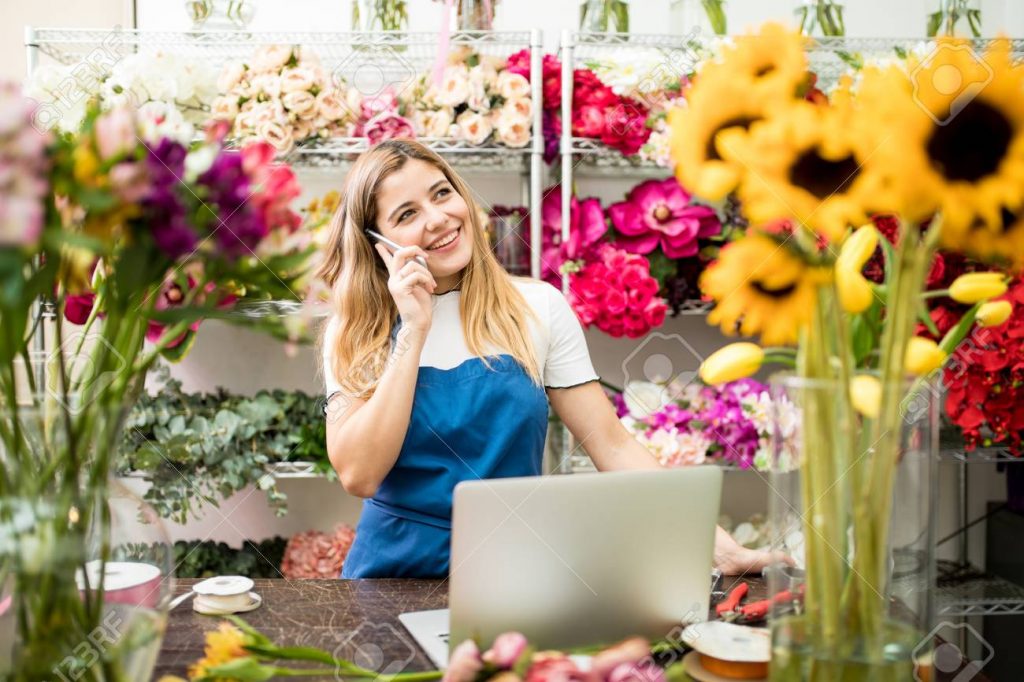 Esta imagen tiene el atributo alt vacío; su nombre de archivo es 78492979-happy-hispanic-flower-shop-owner-taking-a-costumer-order-on-the-phone-while-working-on-her-laptop-co-1024x682.jpg